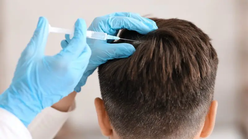 Unrecognizable man having hair treatment at beauty salon